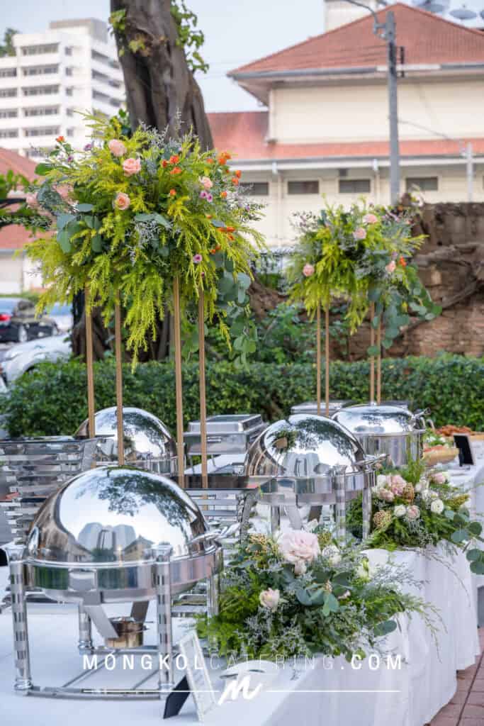 Vibrant floral arrangement with catering setup outdoors in Bangkok, Thailand.