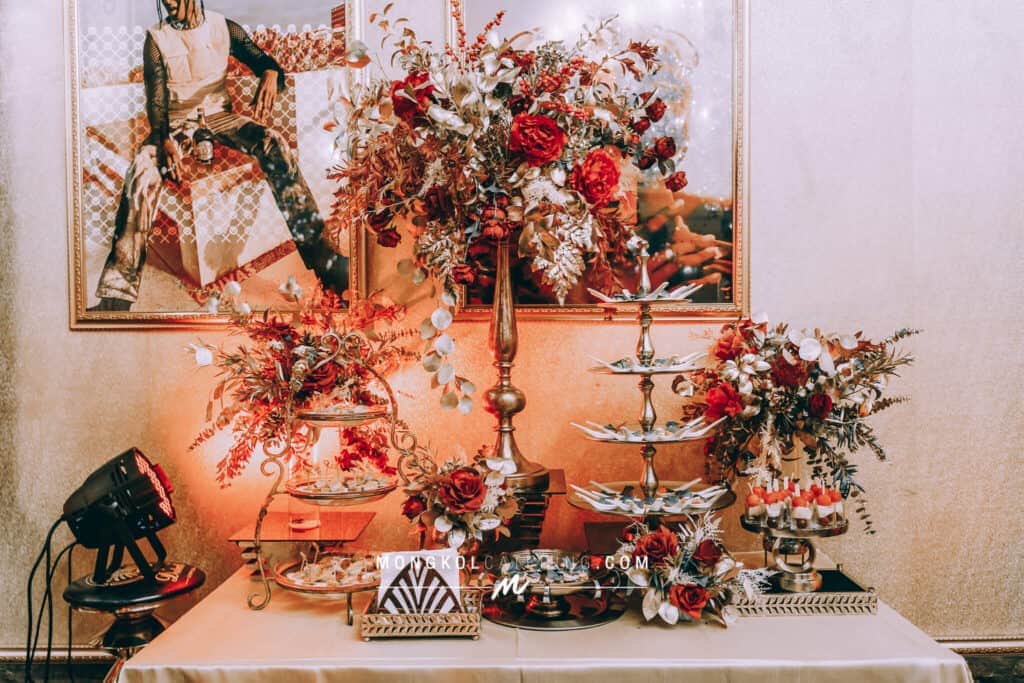 Elegant floral centerpiece and dessert display at Mongkol Catering event in Thailand.