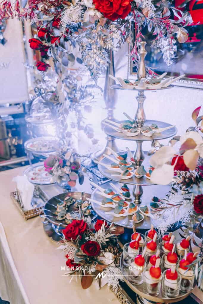 Elegant dessert display with silver tiered trays and floral accents for events in Thailand.