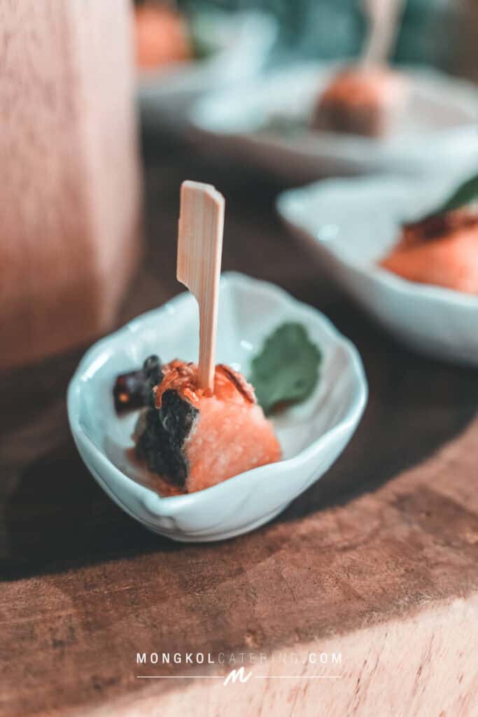Delicious Thai-style appetizer served in a small ceramic dish with a wooden pick.