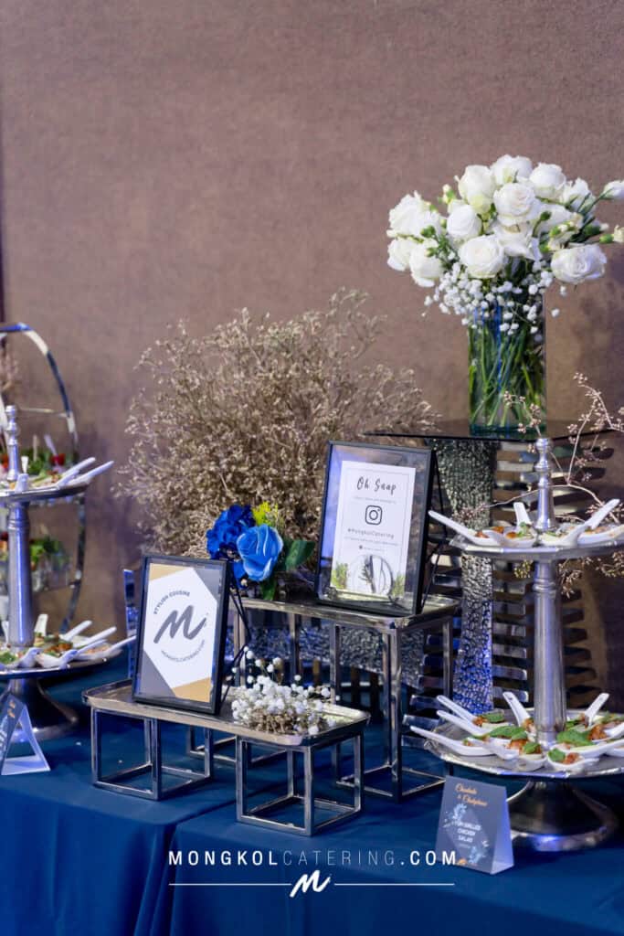 Elegant floral centerpiece with white roses at Mongkol Catering event in Thailand.