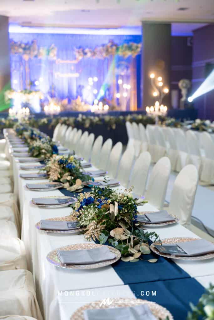 Elegant wedding banquet table setup in Thailand with floral centerpieces and formal place settings.