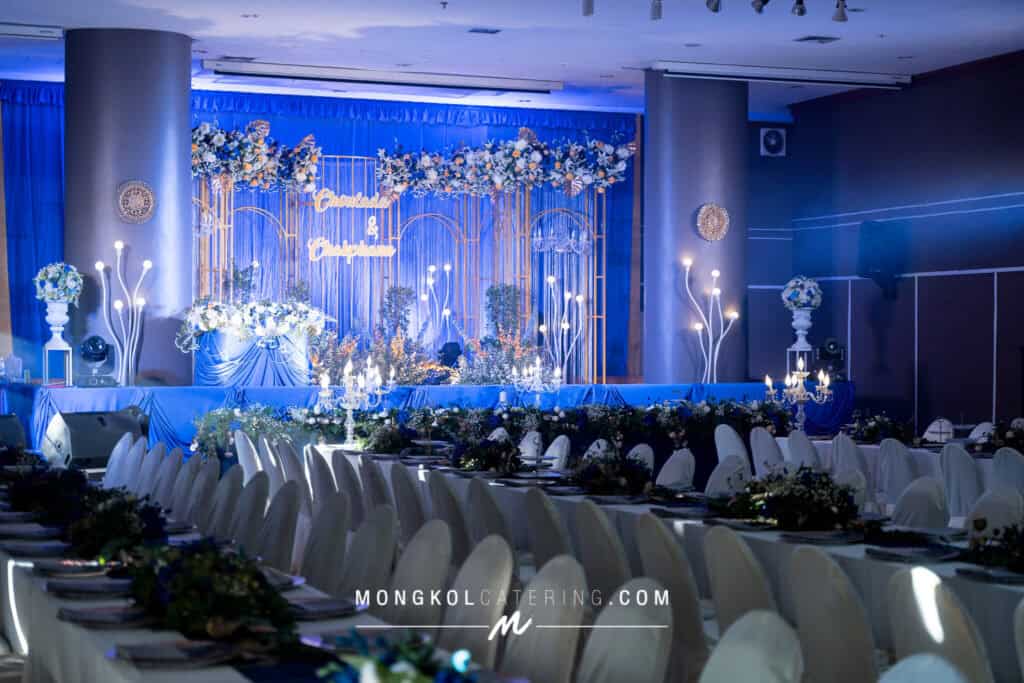Elegant wedding reception decorated with blue-themed floral arrangements in Thailand.