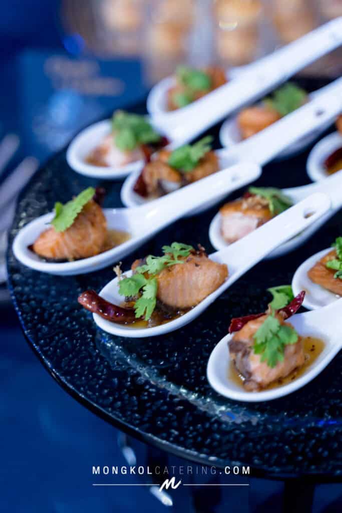 Mini Thai seafood appetizers served on white ceramic spoons at Mongkol Catering event in Thailand.