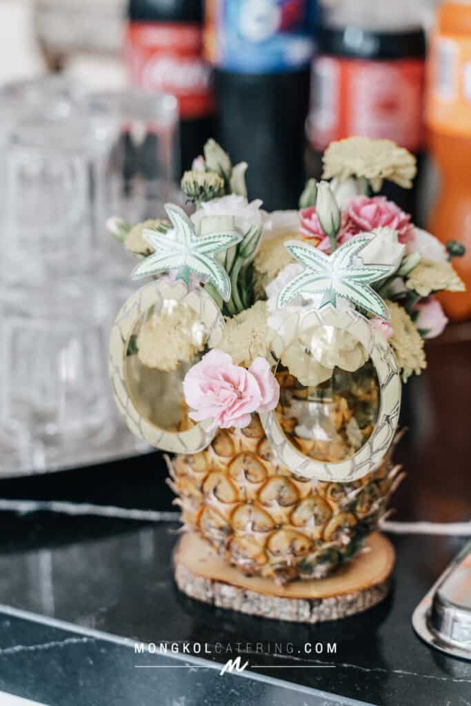 1. Fresh pineapple decorated with flowers and cannabis leaf toppers for event decor in Thailand.