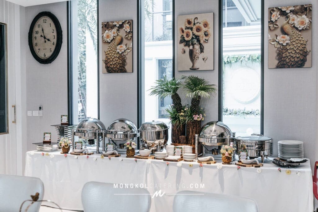 Elegant buffet setup with floral decor in a modern event space in Thailand.