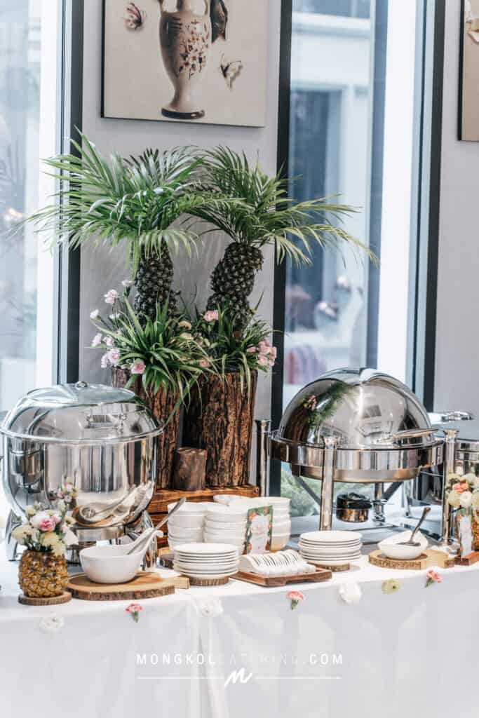 Lush tropical plant centerpiece with pineapples at Mongkol Catering event in Thailand.