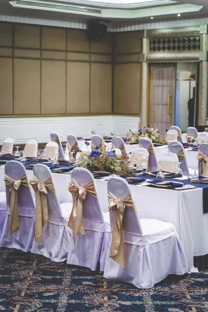 Elegant banquet setup with decorated chairs and floral centerpieces for events in Thailand.
