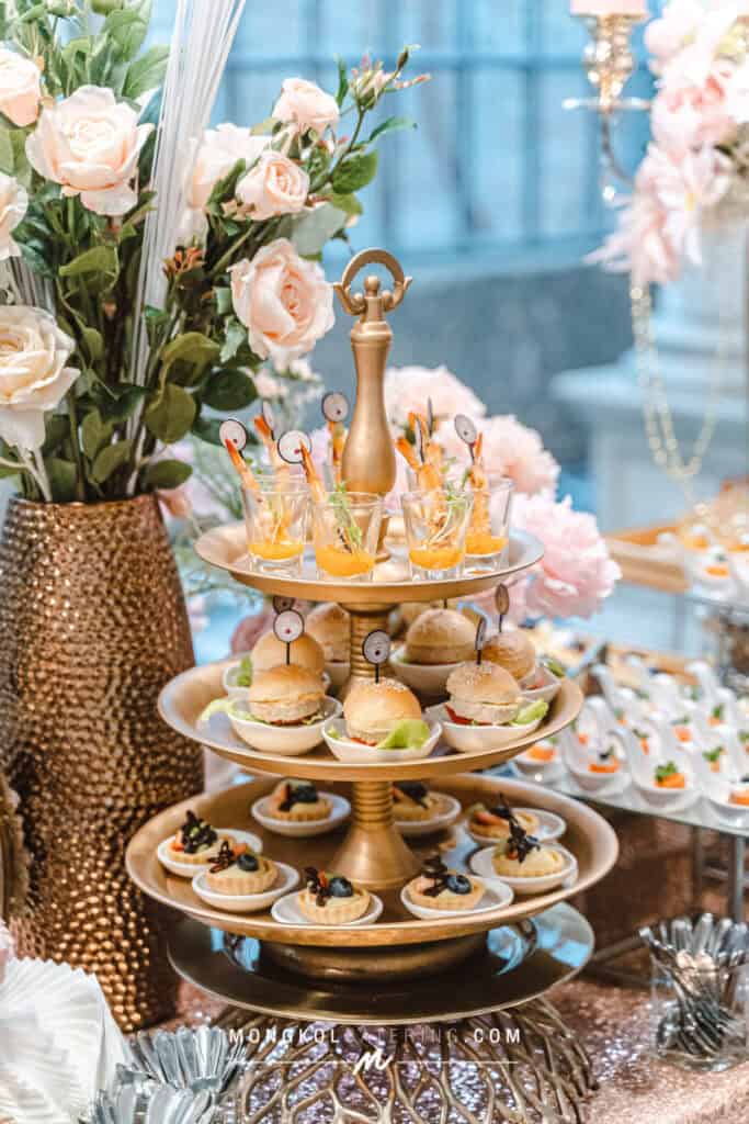 Elegant catering display with mini sandwiches and desserts at a wedding event in Thailand.