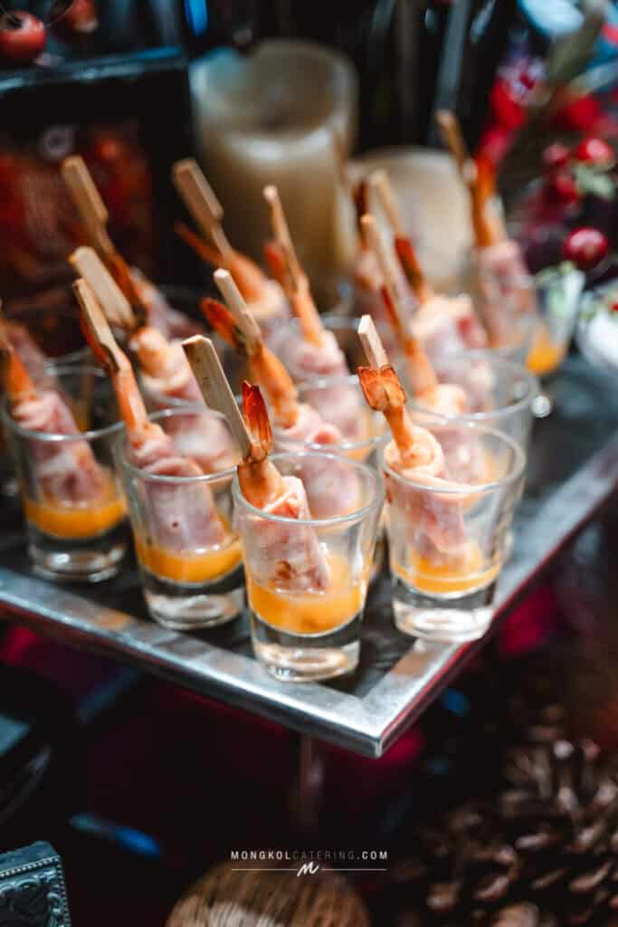 1. Shrimp skewers in glasses with orange sauce at Mongkol Catering event in Thailand.
