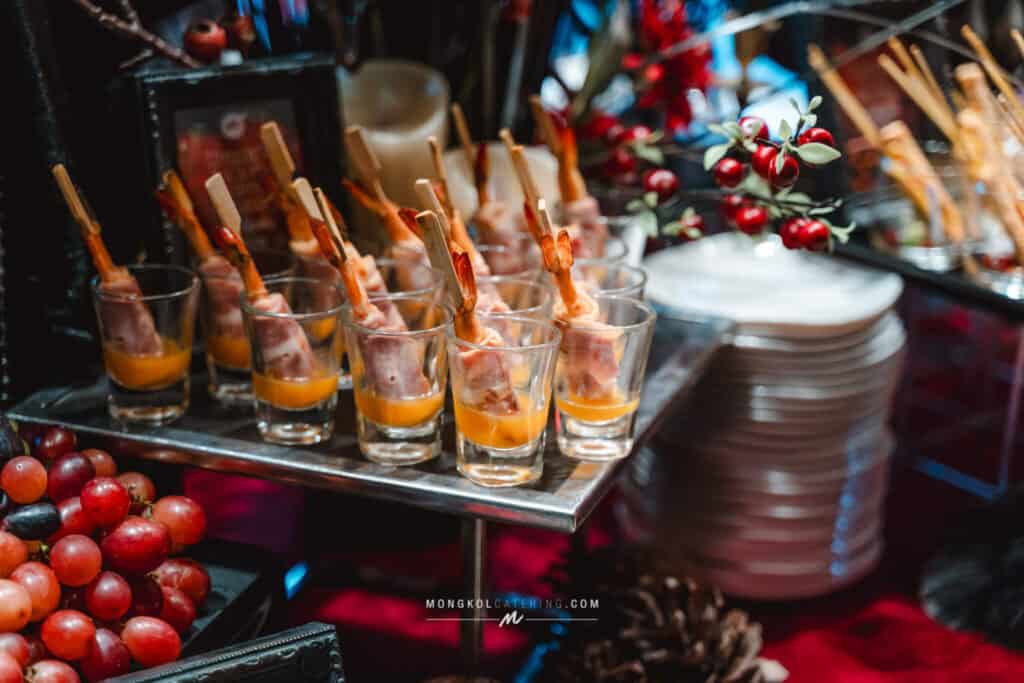 Mini grilled shrimp skewers served in shot glasses at Mongkol Catering event in Thailand.