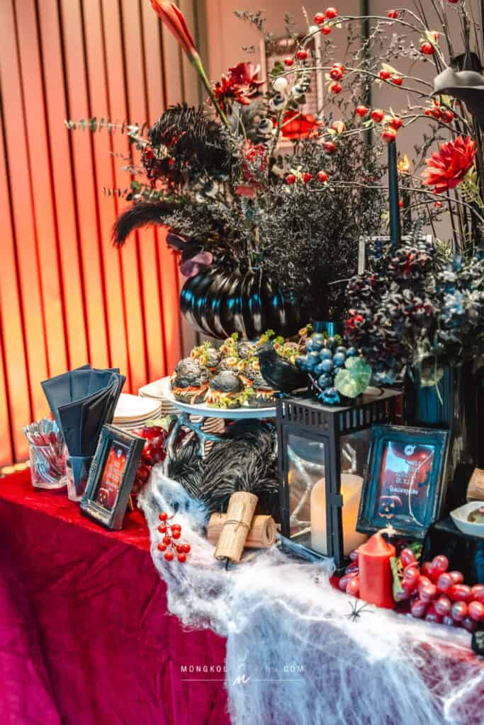 Colorful Halloween-themed event decorations with flowers, candles, and spooky details in Thailand.