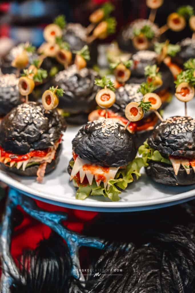 1. Black bun sliders with cheese, olives, and herbs for Thai event catering.