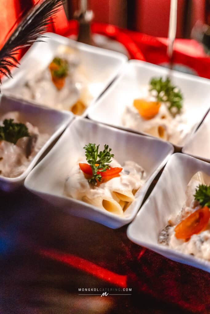 Delicious creamy pasta appetizers with herbs, served in small white bowls at Mongkol Catering Thailand.