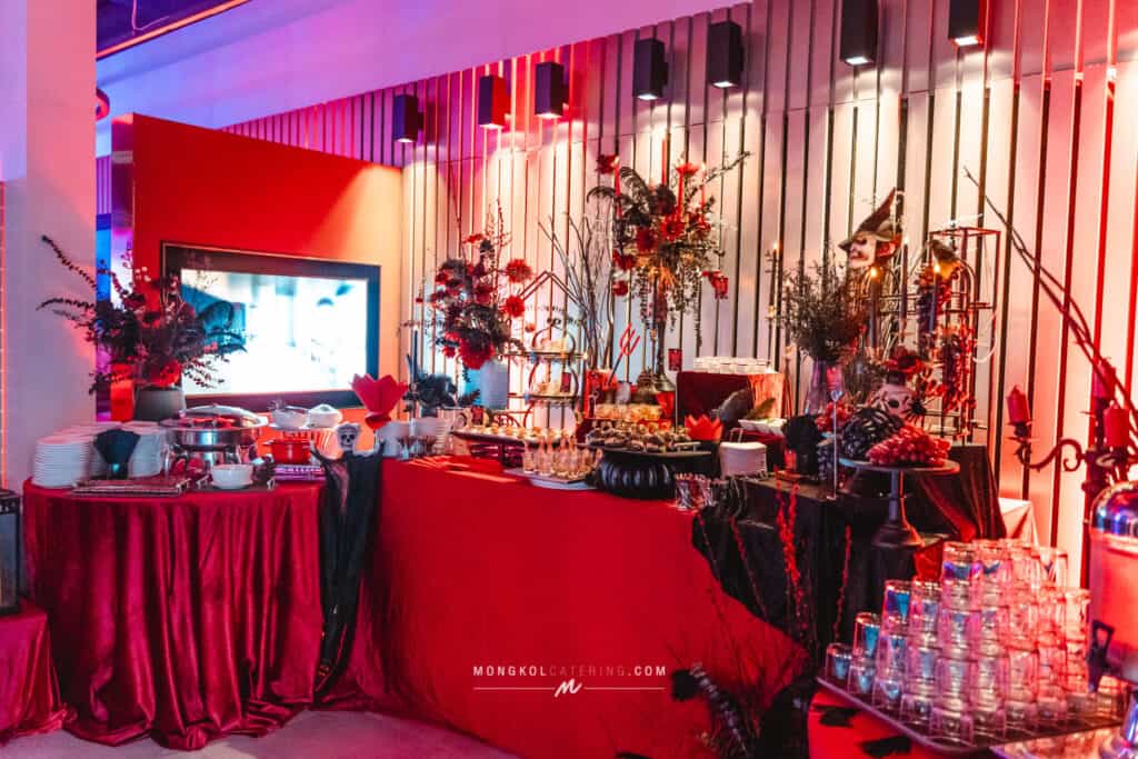 Elegant event setup with red and black decor and floral arrangements in Thailand for catering services.