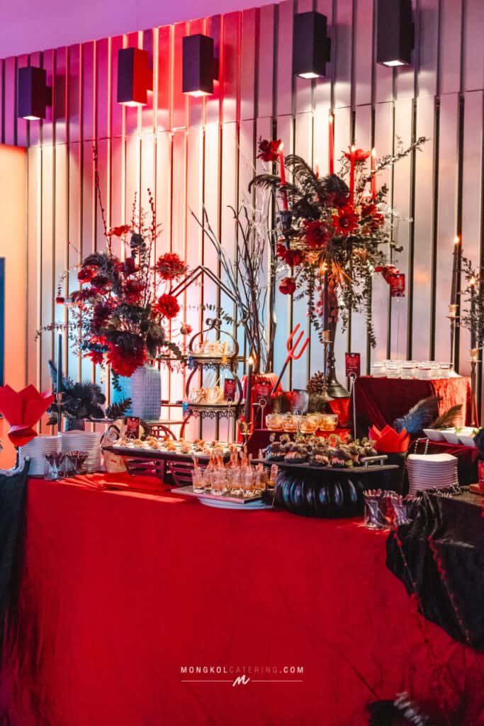 Elegant event table with red floral arrangements and decorative accents at Mongkol Catering Thailand.
