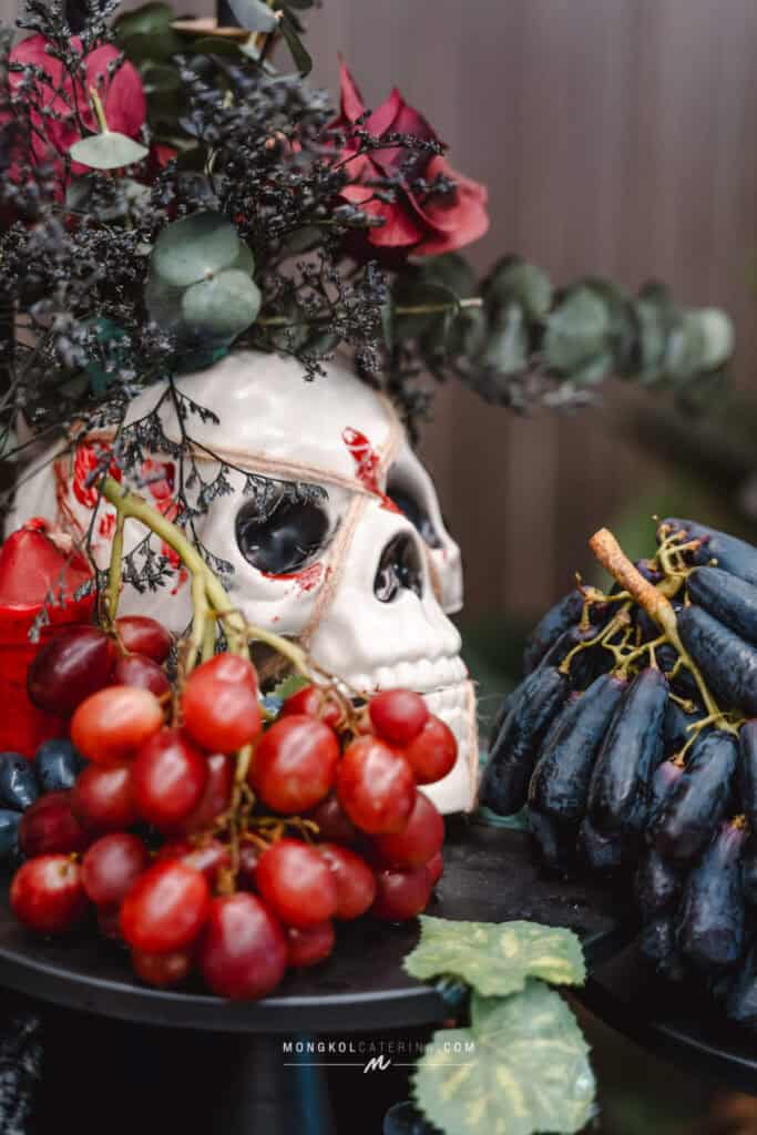 Colorful Halloween-themed decorations with a skull, grapes, and flowers for event catering in Thailand.