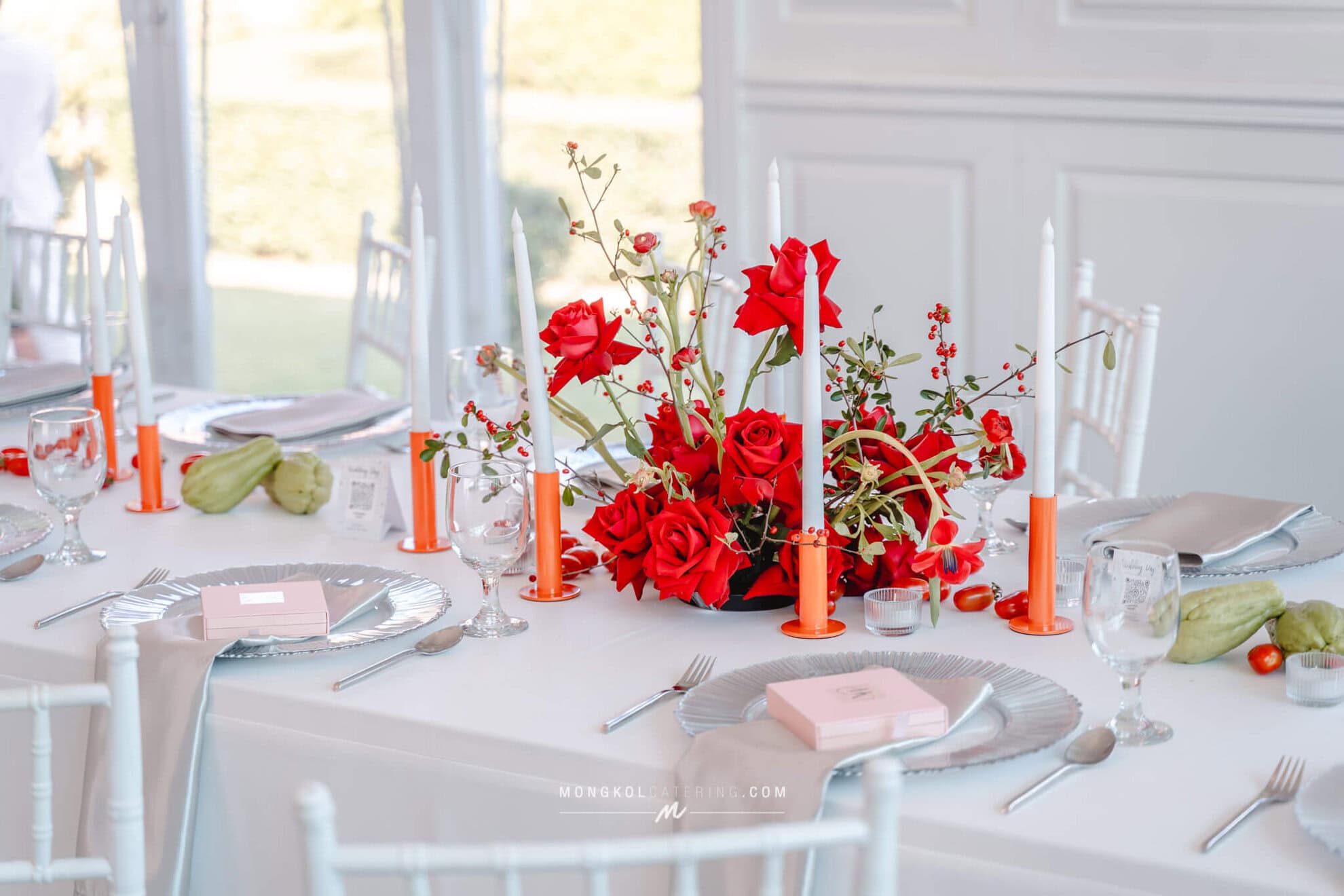 Elegant wedding table setup with vibrant red floral centerpiece in Thailand, perfect for events and celebrations.