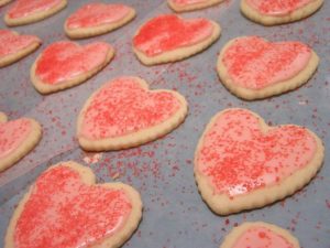 baking sheet with red heart cookies on it