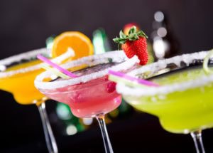 three margaritas lined up against black background