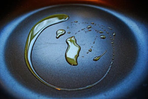 Seasoning involves coating the pan with a layer of oil.