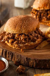 two sloppy joes on cutting board