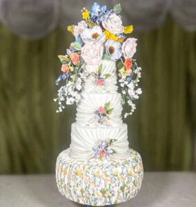 Tiered wedding cake inspired by Florentine artistry and Caterina de Medici, with Renaissance garden flowers, draped fondant, and hand-painted Florentine pattern in Florence, Italy.