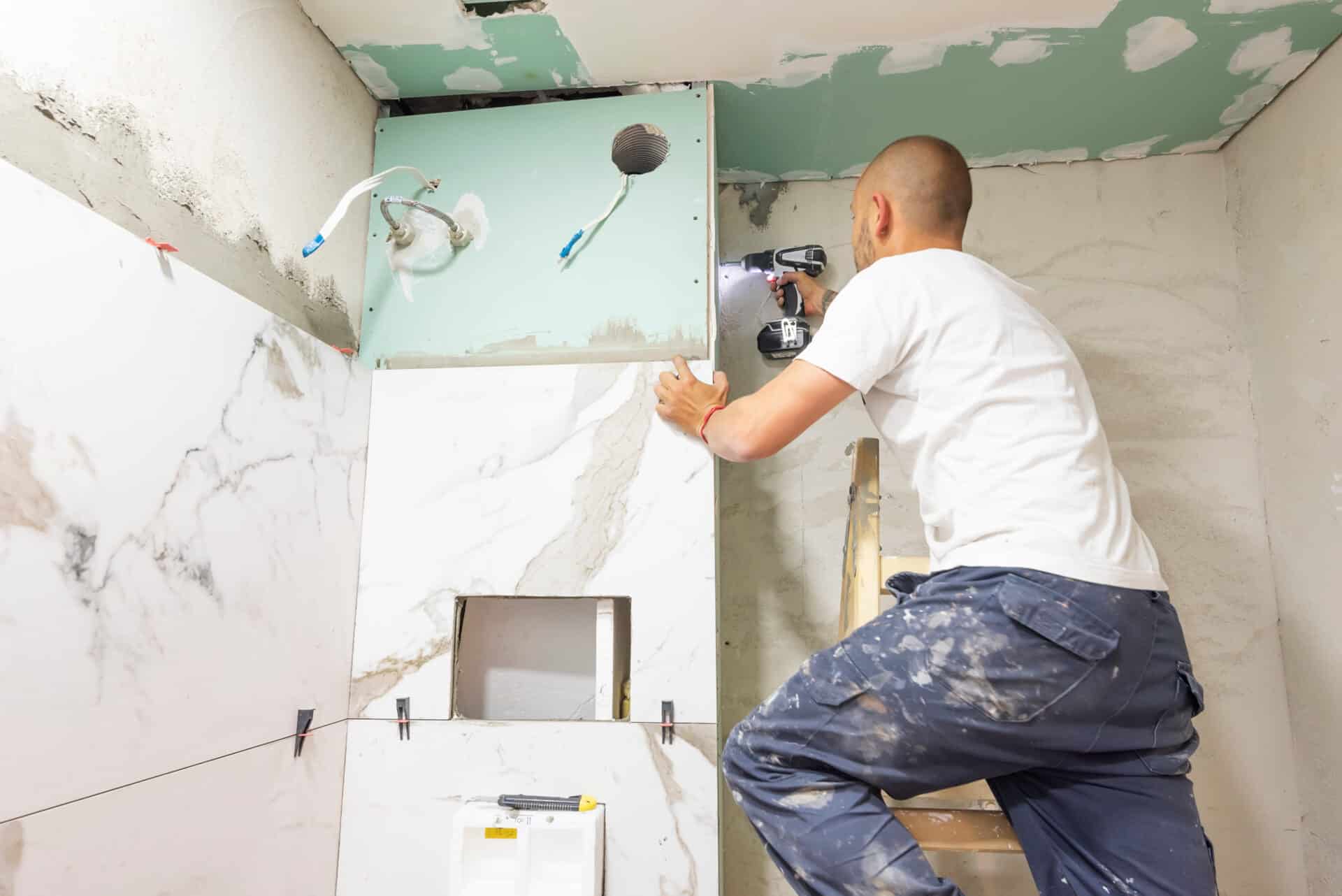 Plumber using electric screwdriver. Bathroom renovation concept.