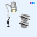 The Sunflower II LED Nail Dust Collector features a silver, flexible-arm LED light with a vented cylindrical head that emits a bright yellow beam. It attaches securely to surfaces with a sturdy metal clamp, shown against a pale blue background. There are also a pile of filters indicating the extra package that comes with the Sunflower II Extra Value Package. Read more at Aerovex Systems (aerovexsystems.com)