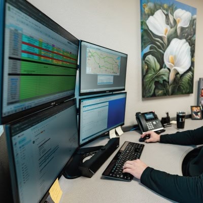 Air traffic control workspace with multiple monitors displaying flight data and maps.
