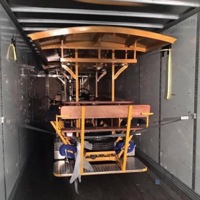 Wooden transport cart inside a truck for airport logistics.