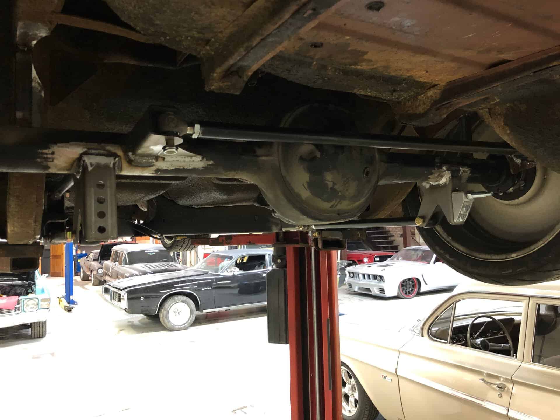 High-performance automotive differential and suspension upgrades under a classic car.