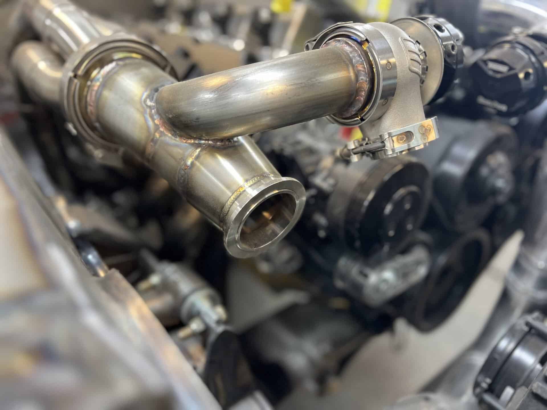 Close-up of custom exhaust pipe in a car engine.