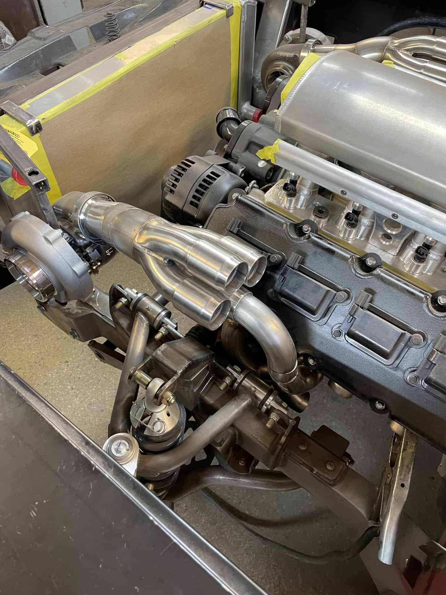 Detailed view of a custom car engine with polished components and turbocharger.