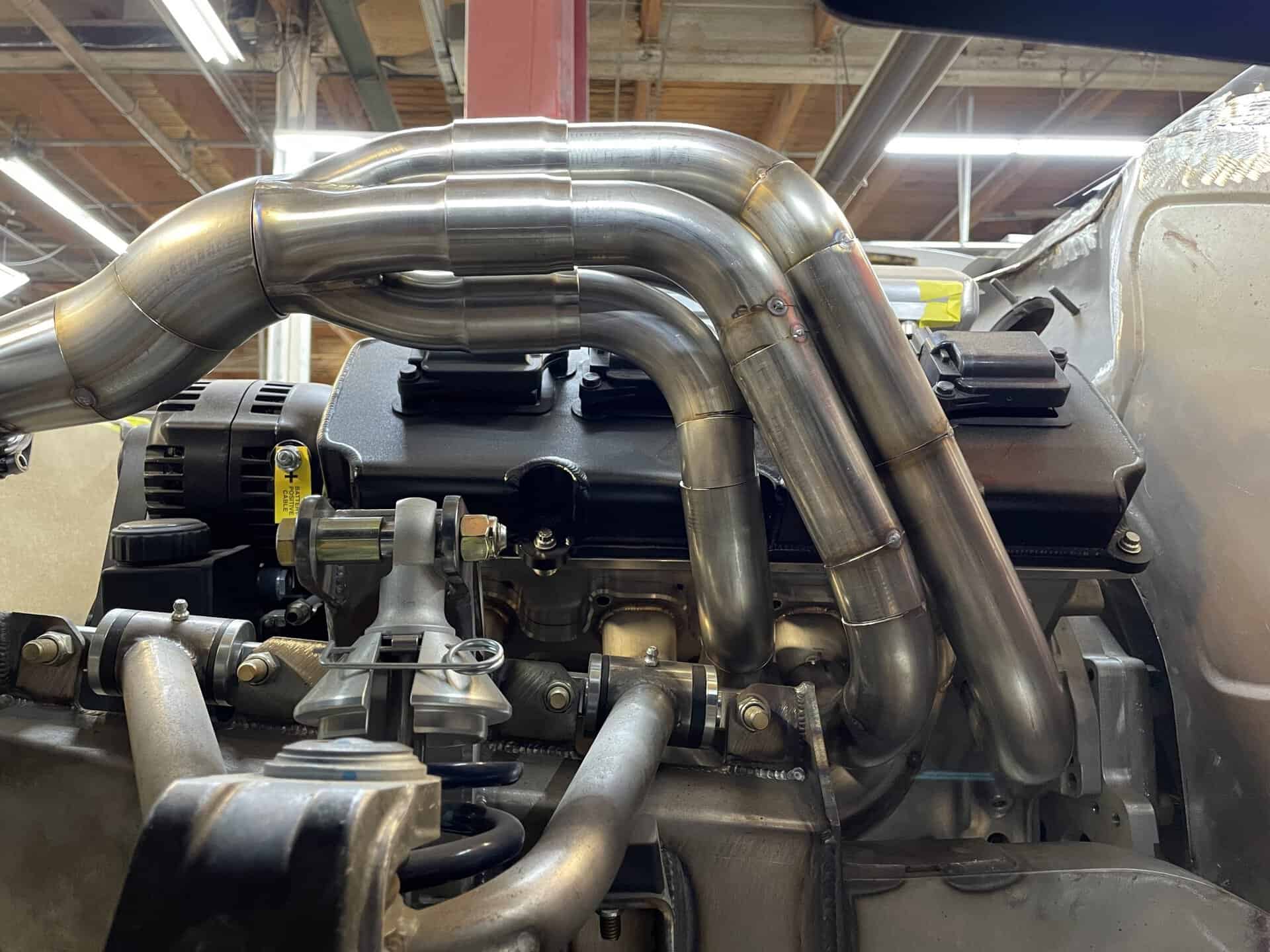 Close-up of custom stainless steel exhaust pipes on engine.