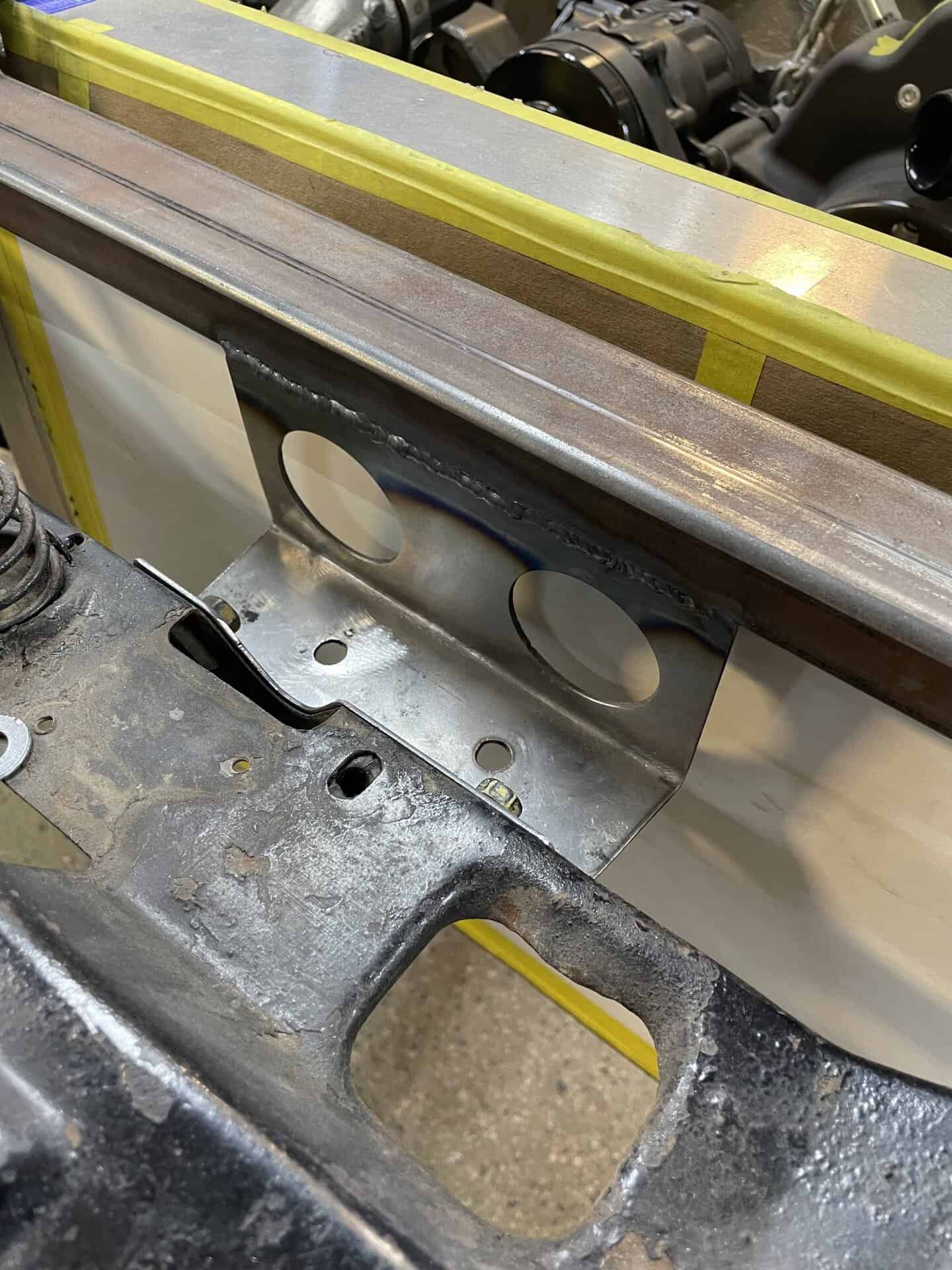 Close-up of metal welding and fabrication in car restoration process.