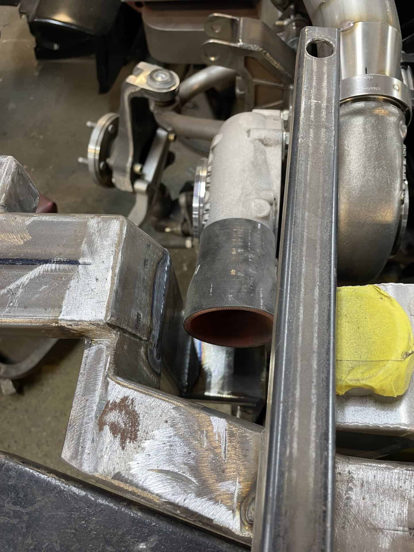 Close-up of engine parts and metalwork in a workshop setting.