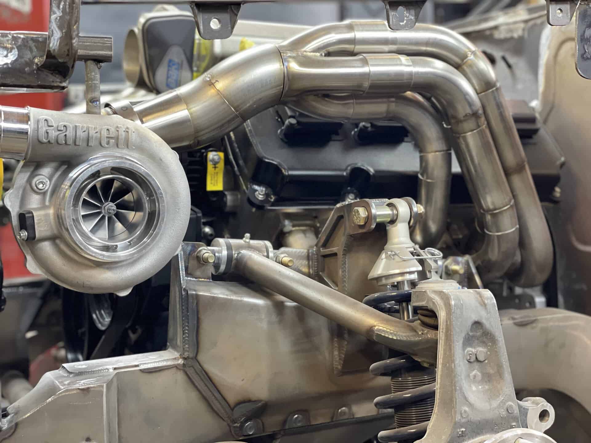 Close-up of turbocharger and exhaust pipes in a car engine.