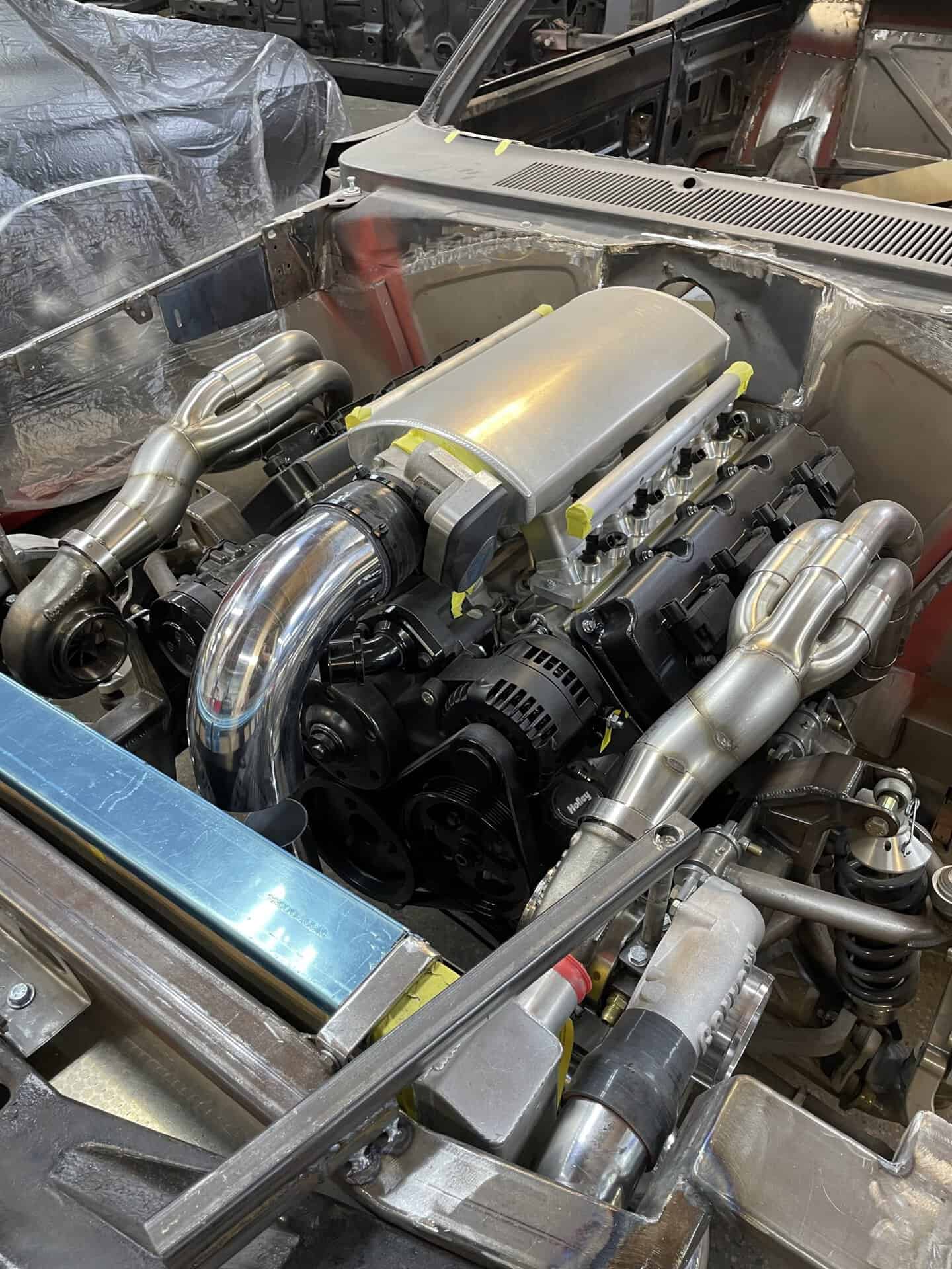 Custom built engine with polished metal components in a classic car.