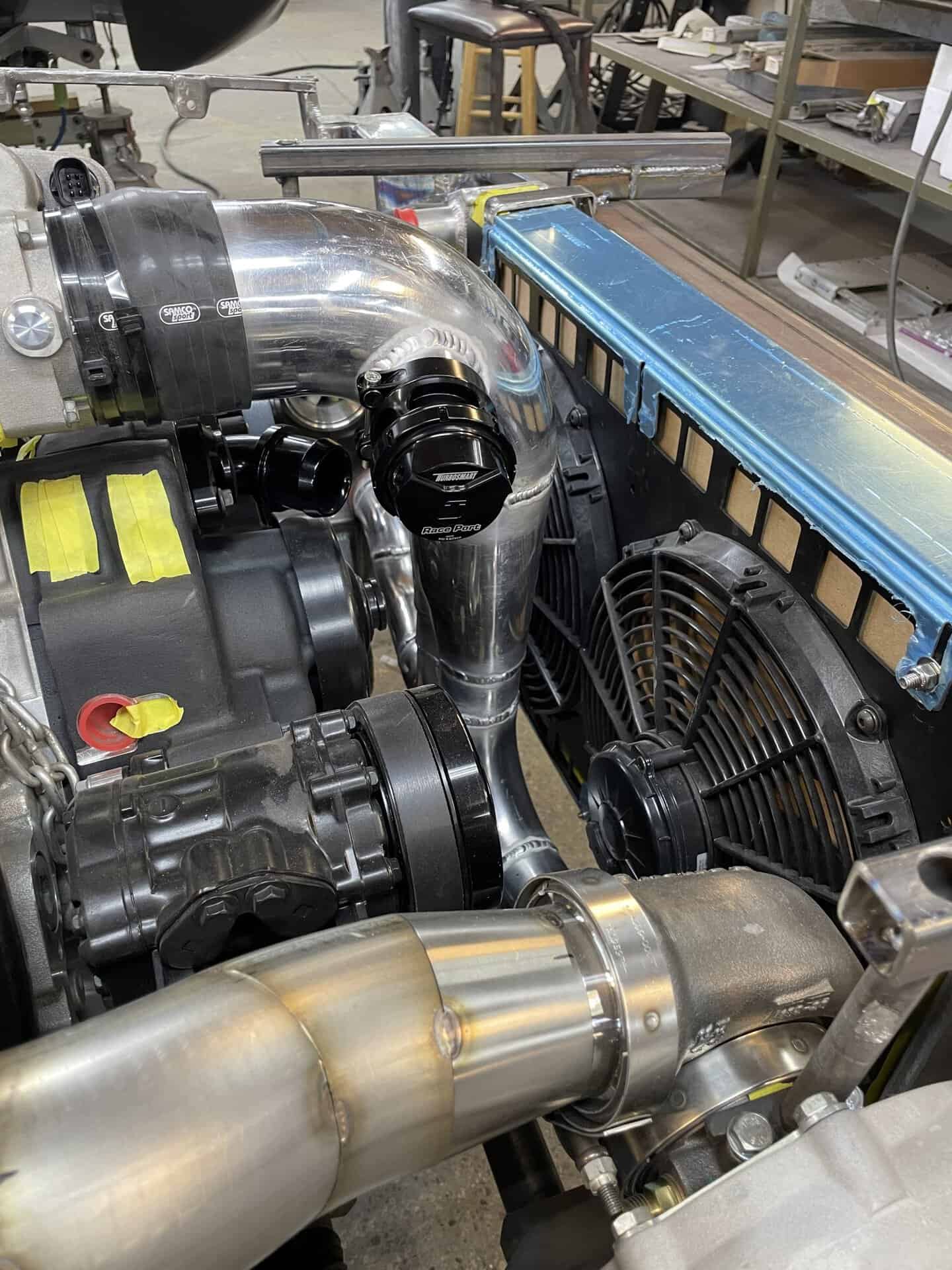 Close-up of a custom car engine with polished metal parts and cooling system.