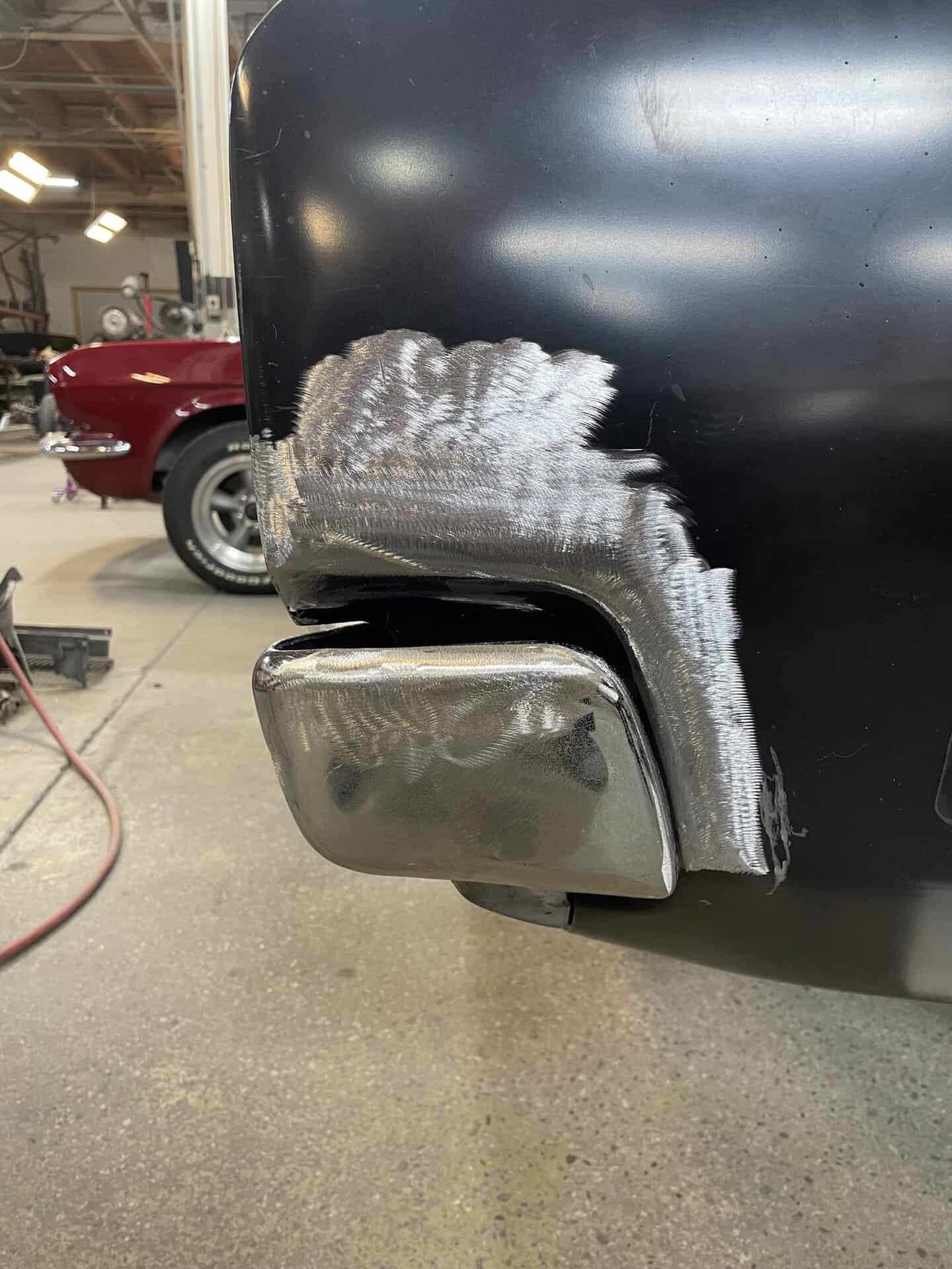Close-up of black Dodge Charger with bodywork repair in progress.