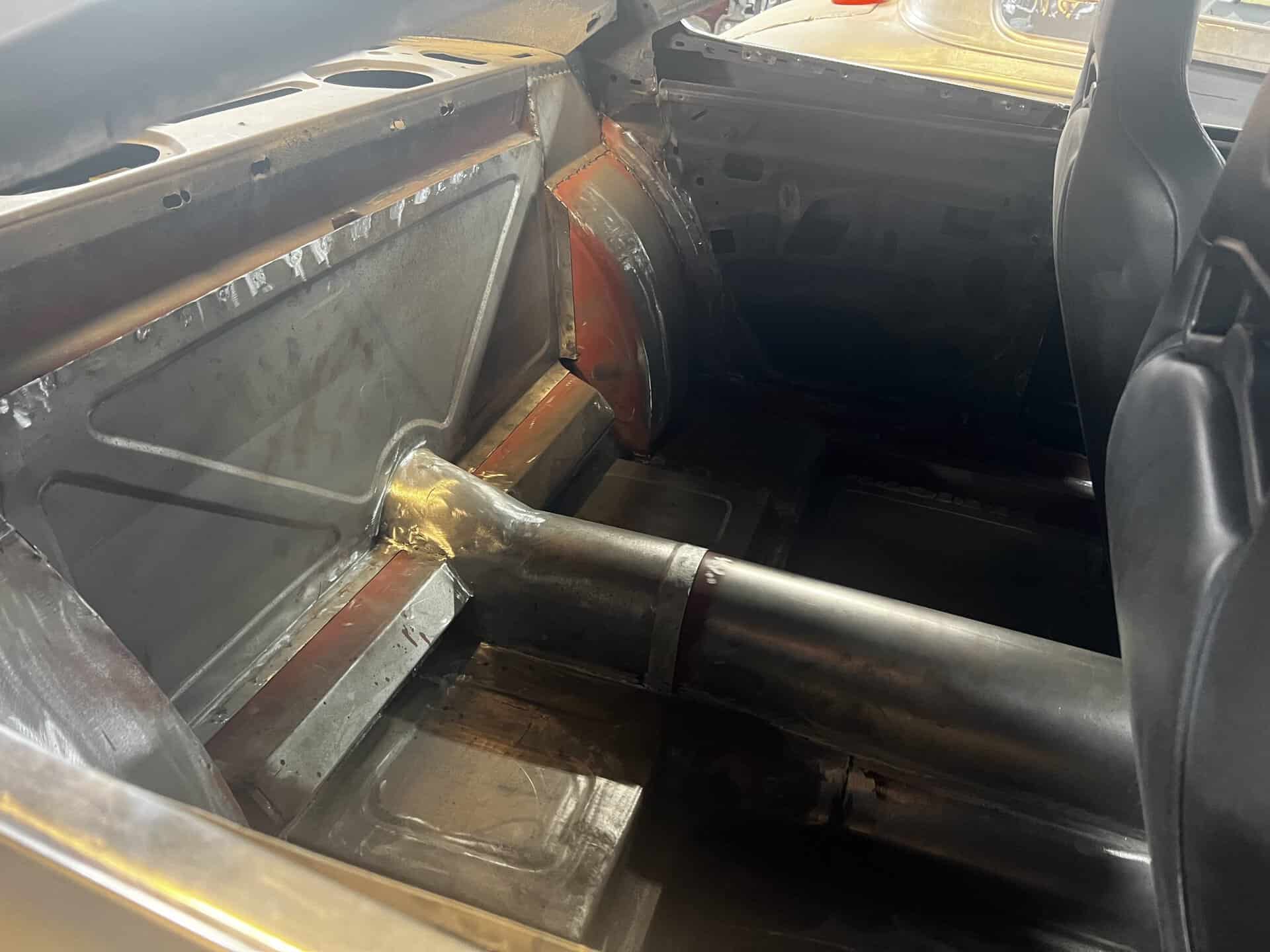 Close-up of custom car interior with metal framework and roll cage.