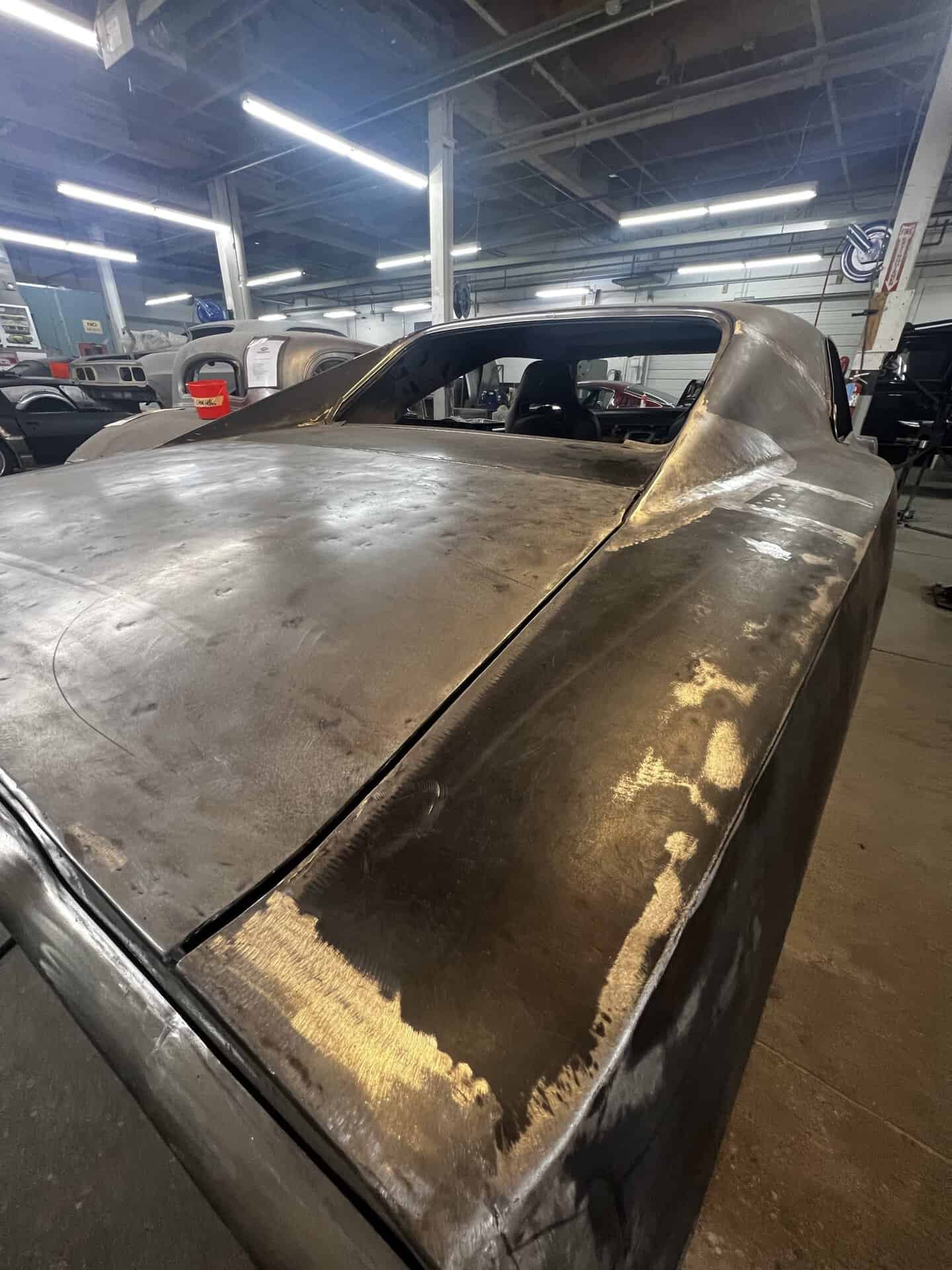 1968 Dodge Charger in restoration shop with weathered body panels.
