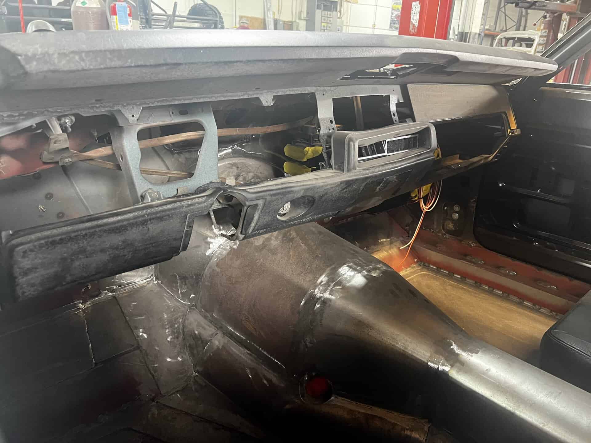 Interior of a 1968 Dodge Charger in restoration with dashboard and wiring visible.