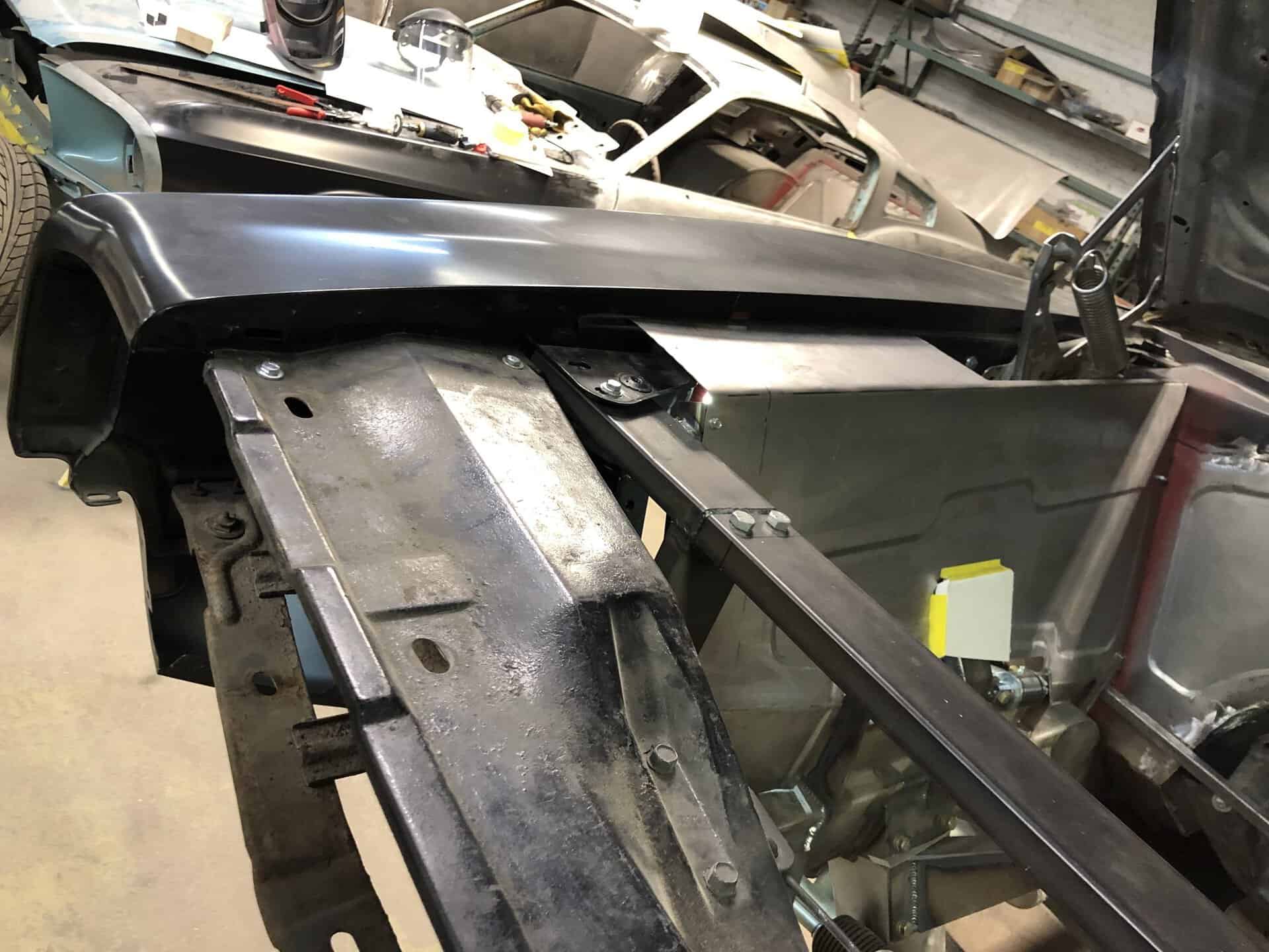 Partially assembled 1968 Dodge Charger in workshop with tools and parts.