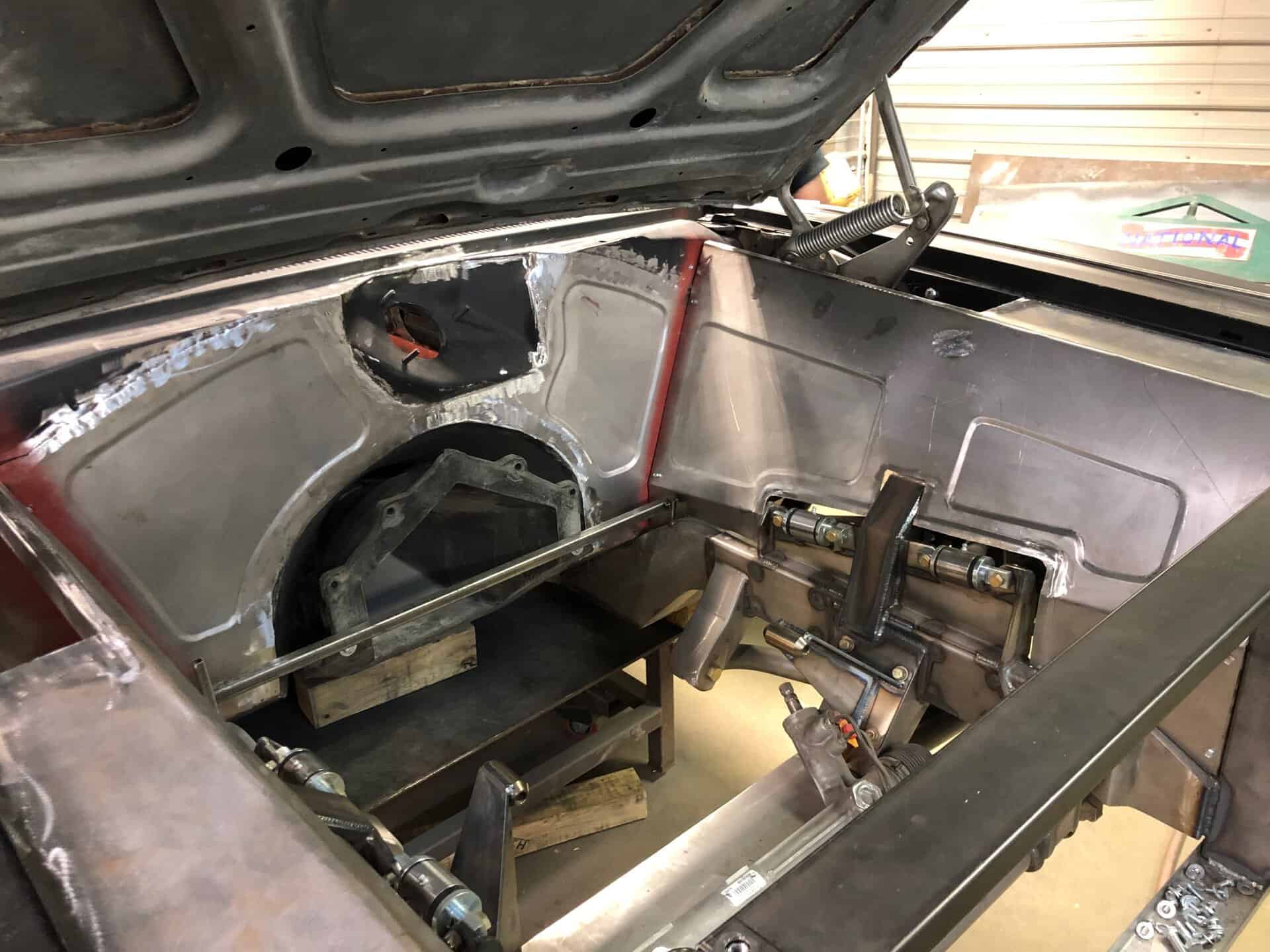 Car interior with custom metal frame and racing steering wheel.