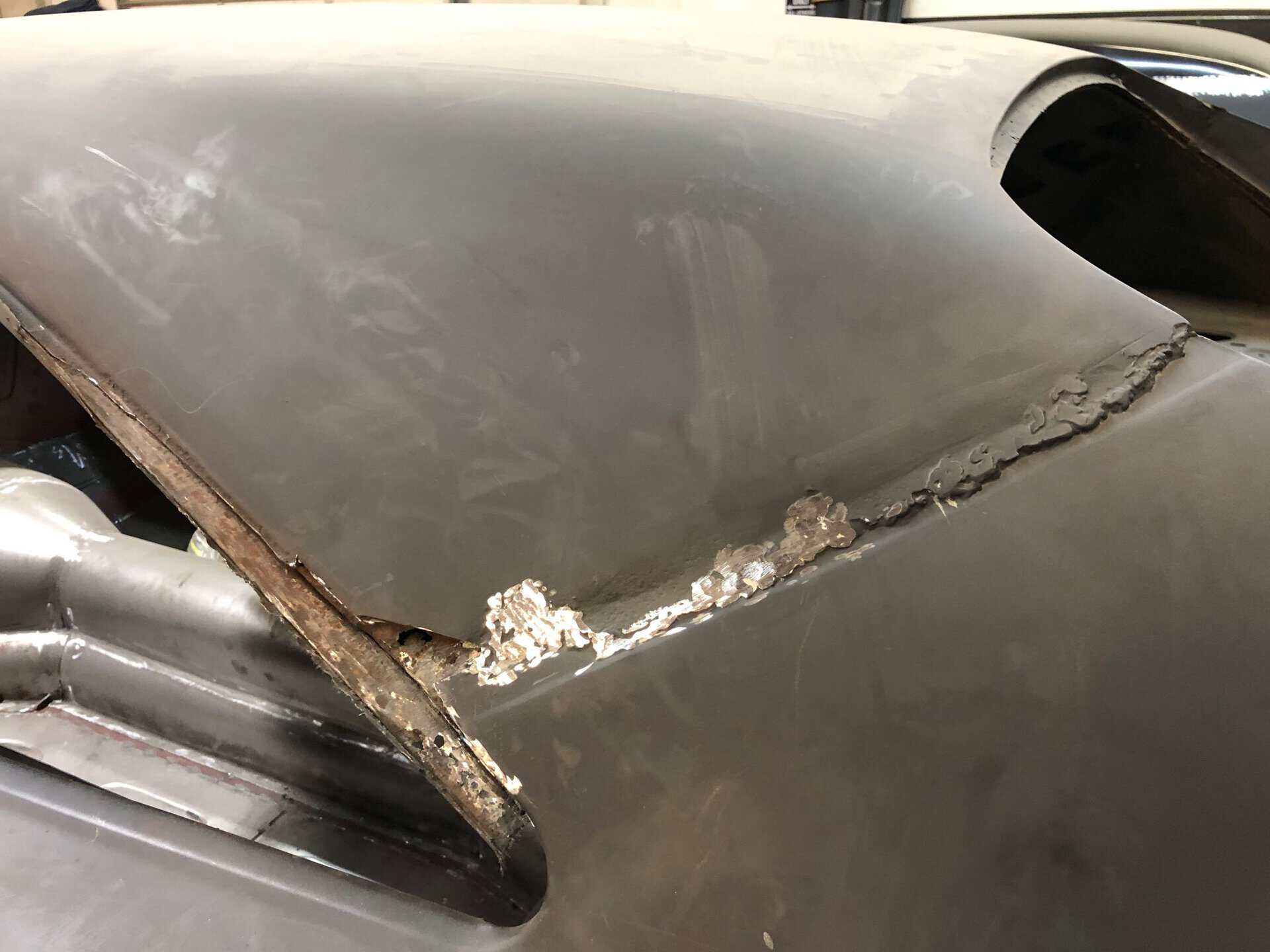Close-up of a damaged car hood with rust and dents from 1968 Dodge Charger.
