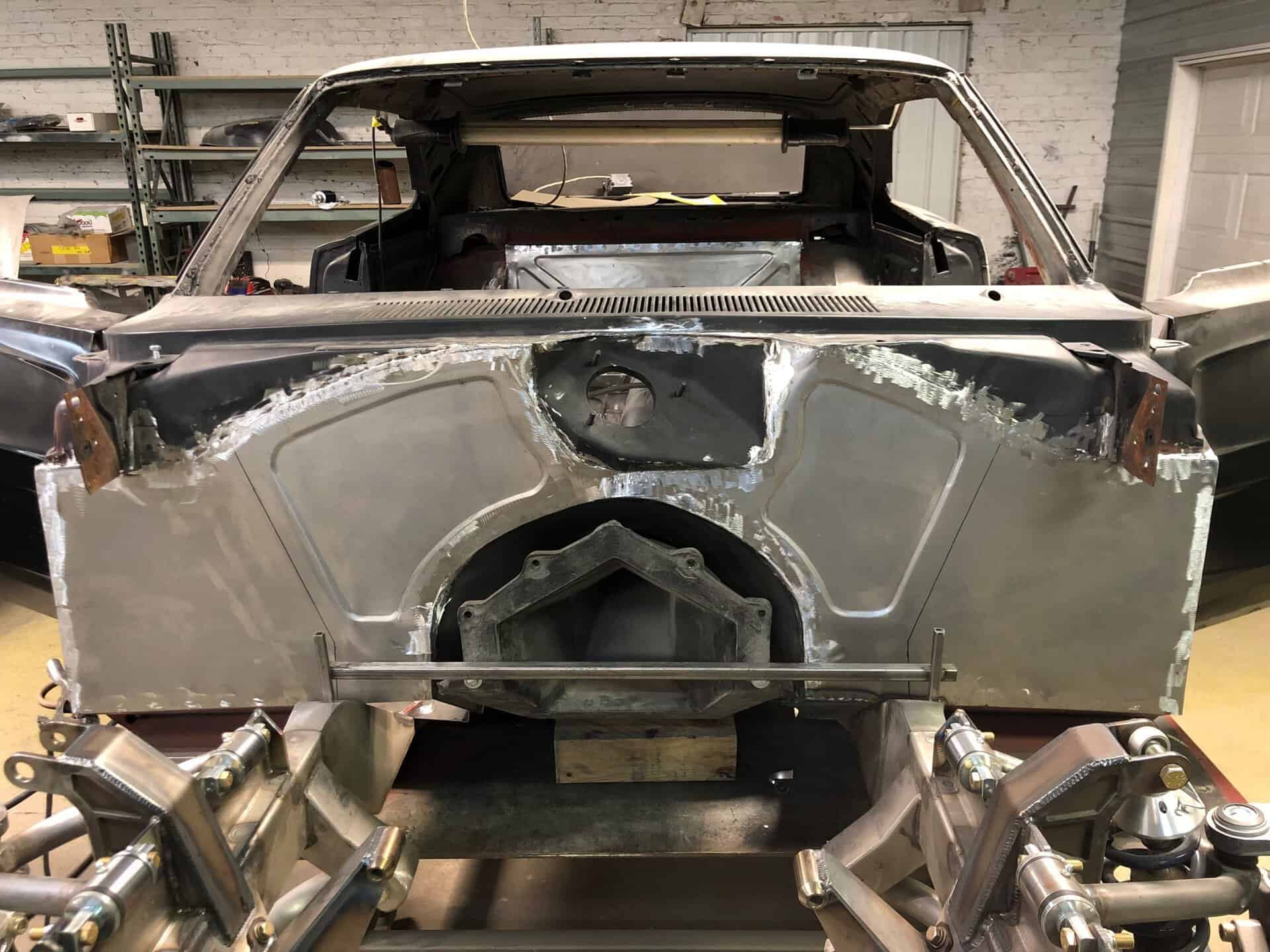1968 Dodge Charger in restoration process with exposed metal body and frame.