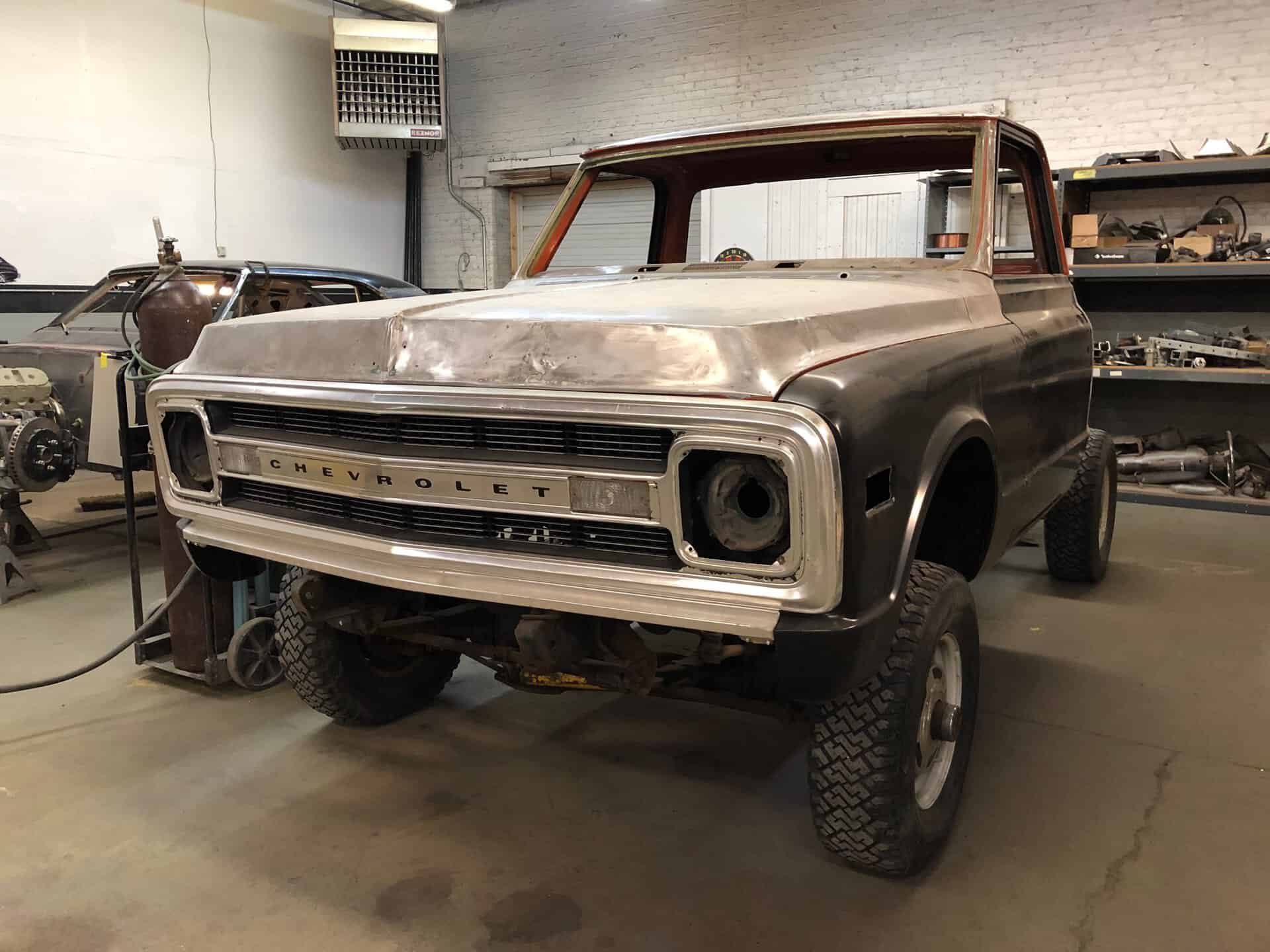 Unfinished 1969 Chevrolet K20 pickup truck in a workshop setting.