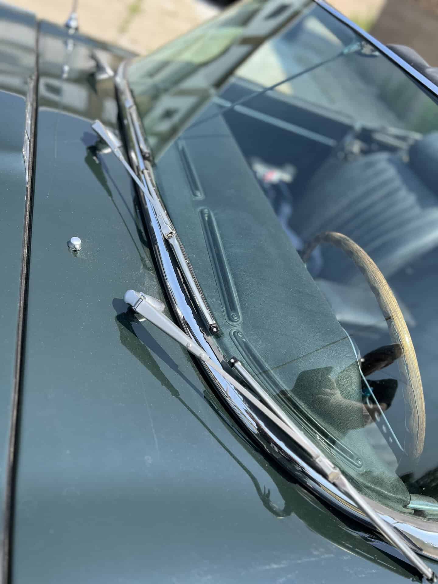 Close-up of vintage Jaguar E-Type dashboard and steering wheel.